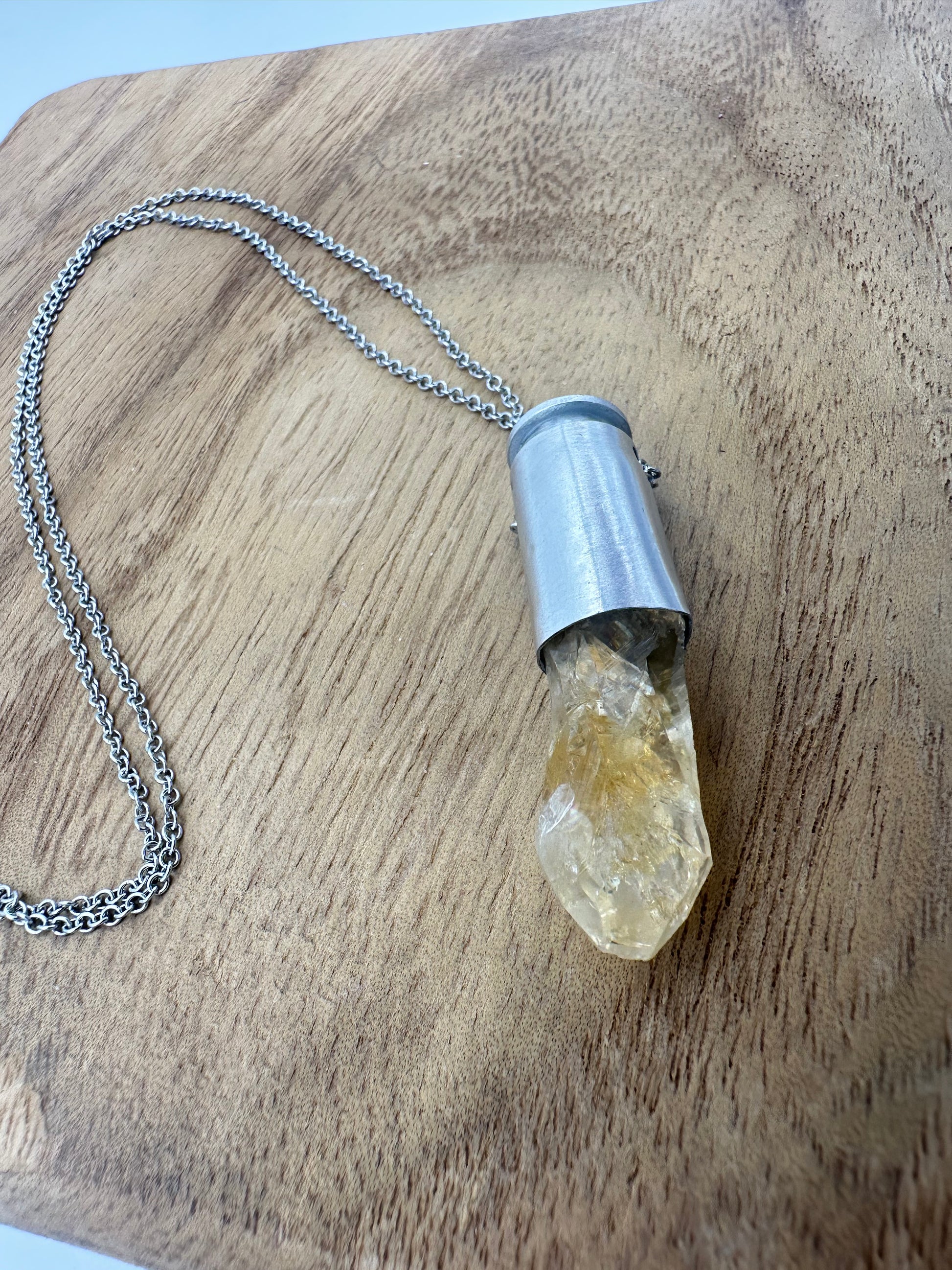 Handcrafted necklace with reclaimed 40 caliber silver bullet casing and natural citrine point pendant on 20-inch steel chain