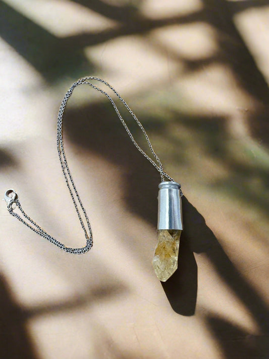 Crystals & Casings necklace featuring upcycled 40 caliber silver casing with golden citrine crystal point on 20-inch steel chain