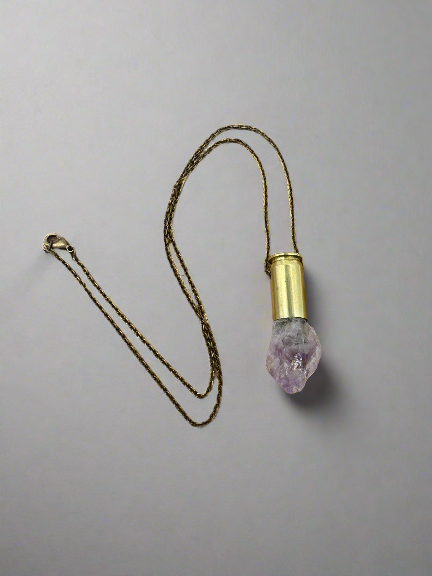 Crystals & Casings necklace featuring upcycled .45 bullet casing with amethyst crystal point on brass chain