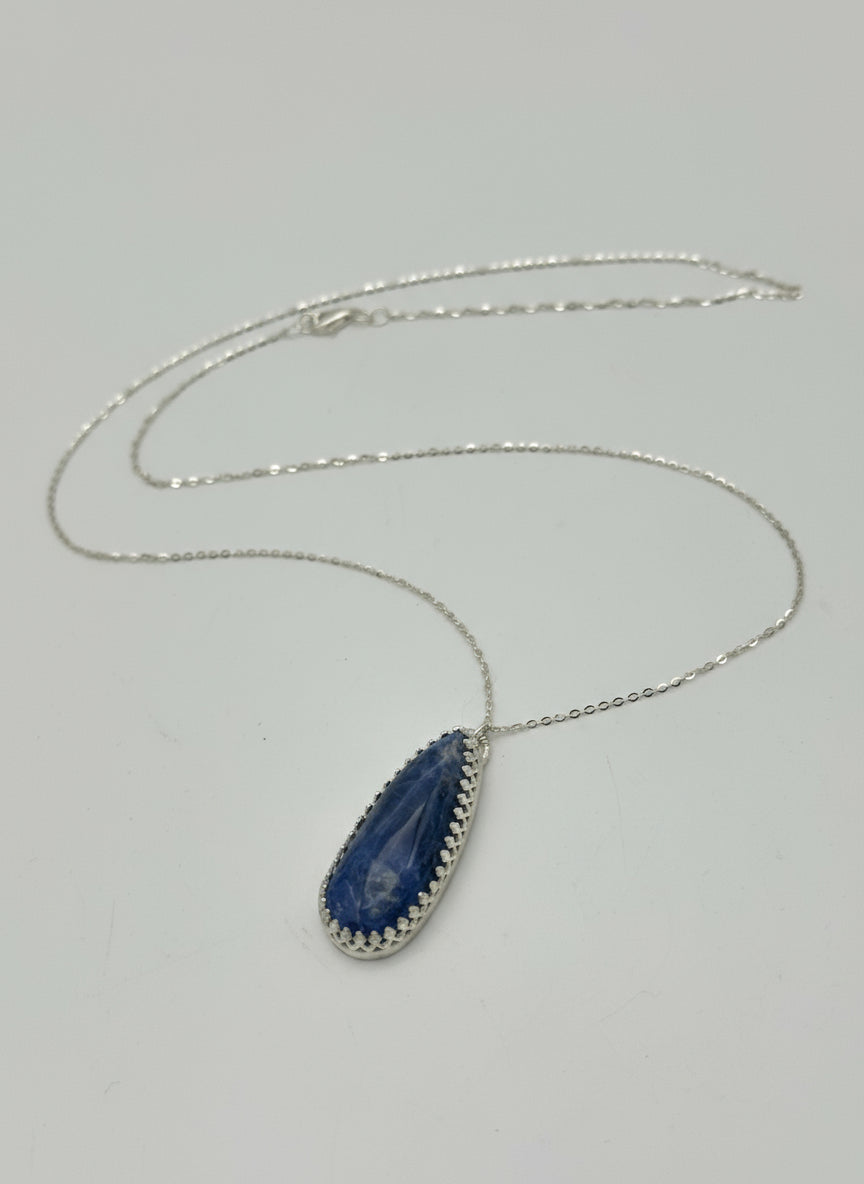 Necklace with a blue pendant on a gray background