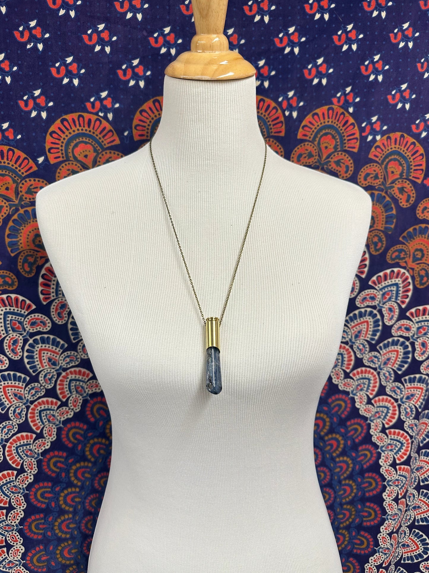 Winchester 6.5 casing and kyanite pendant necklace on 26-inch brass chain, styled as boho statement jewelry