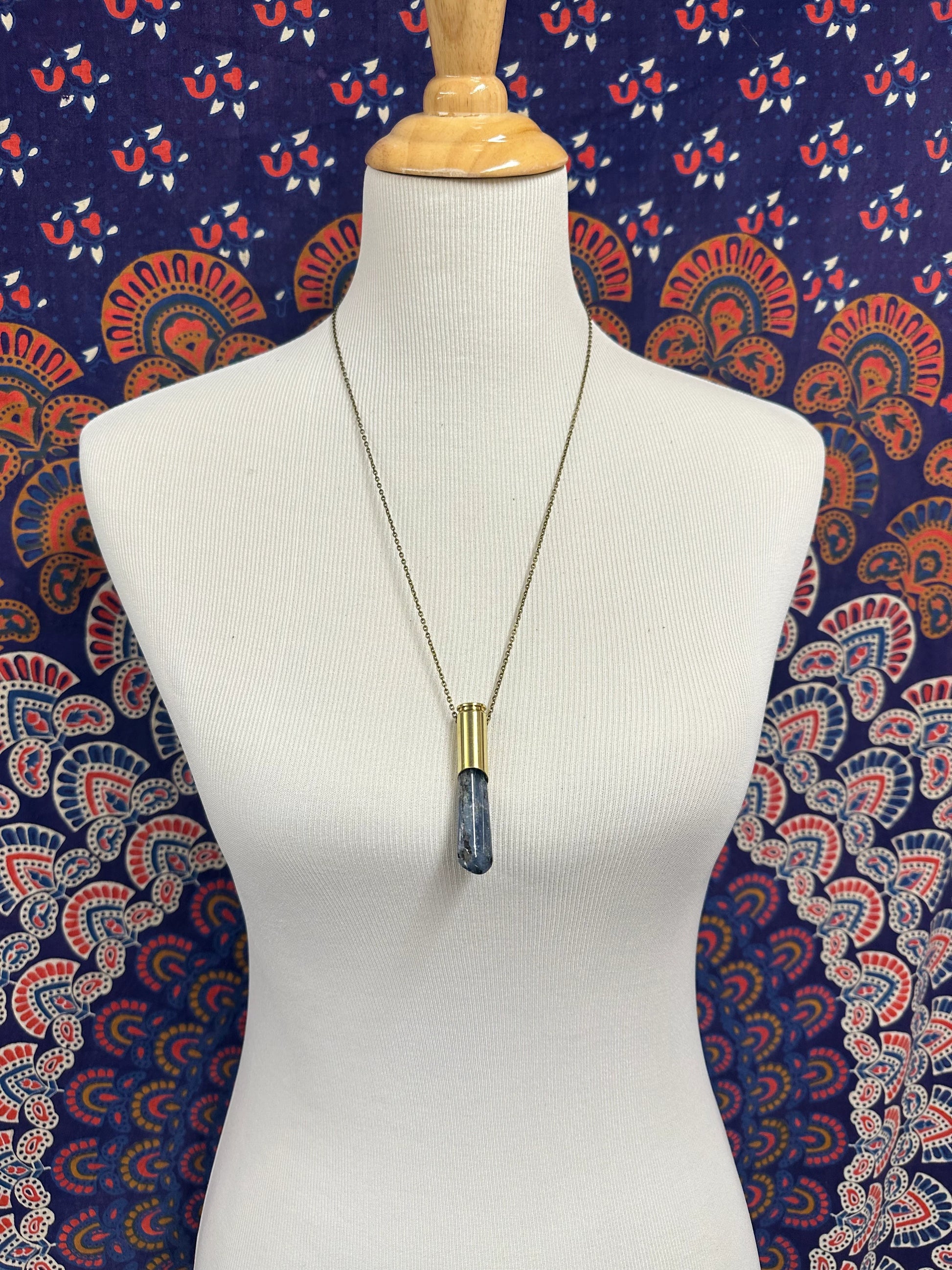 Winchester 6.5 casing and kyanite pendant necklace on 26-inch brass chain, styled as boho statement jewelry