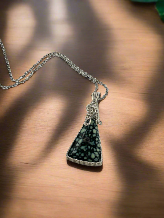 Necklace with a triangular pendant on a light gray background