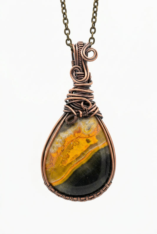 Pendant with a yellow and black stone on a wooden surface