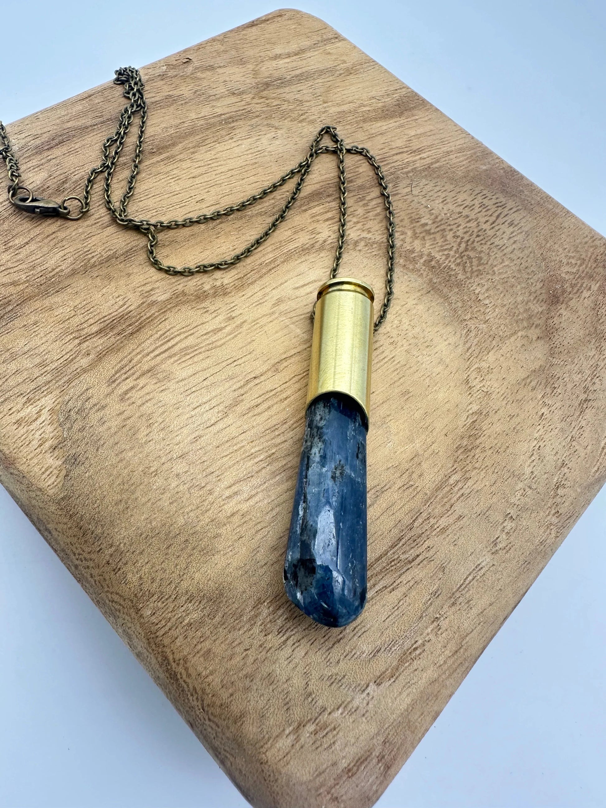 Crystals & Casings necklace featuring upcycled Winchester 6.5 bullet casing and kyanite crystal on long brass chain