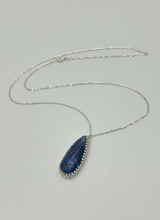 Necklace with a blue pendant on a gray background