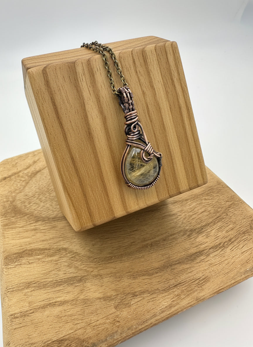 Detail shot of the brass chain and copper bail on the golden rutile quartz necklace.