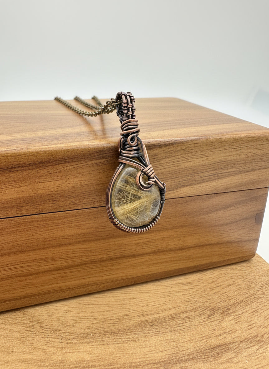 Side angle of the copper wire wrap detailing around the golden rutile quartz pendant