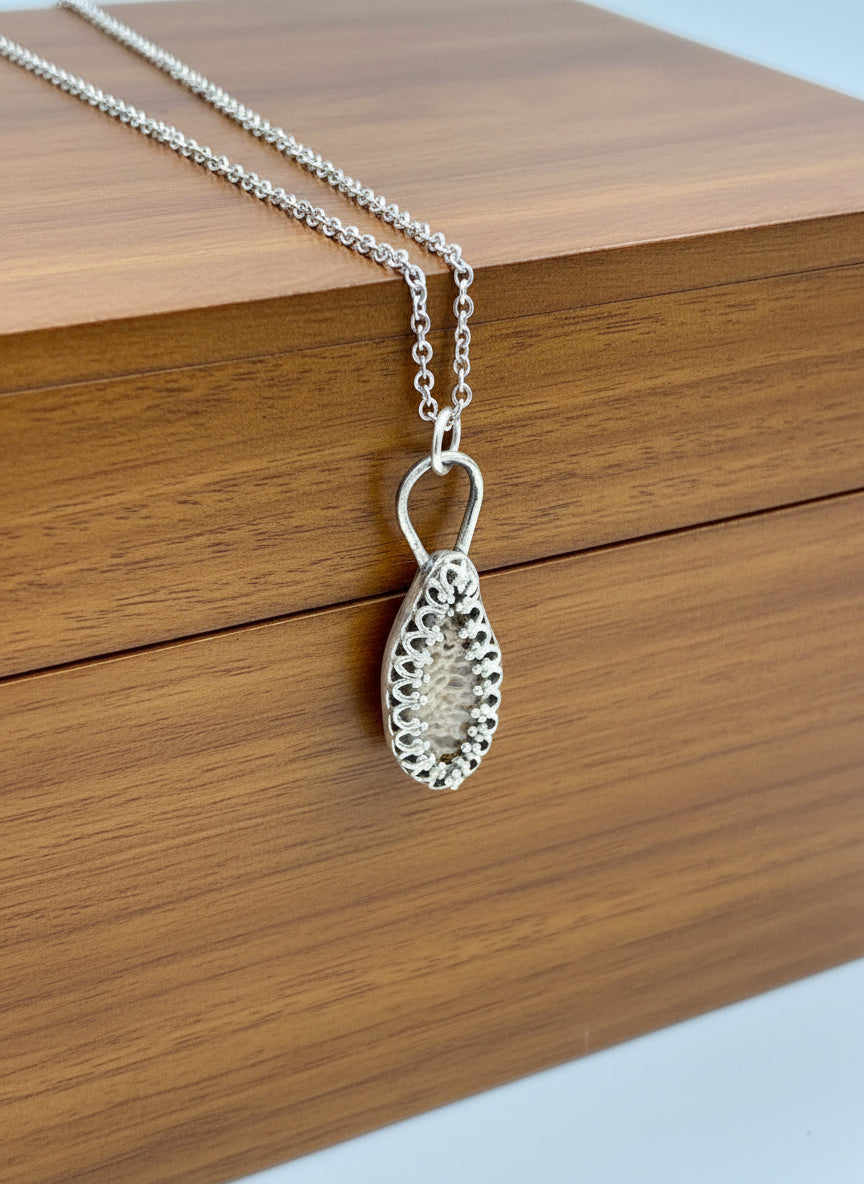 Side angle view of sterling silver deer ribcage bone jewelry pendant