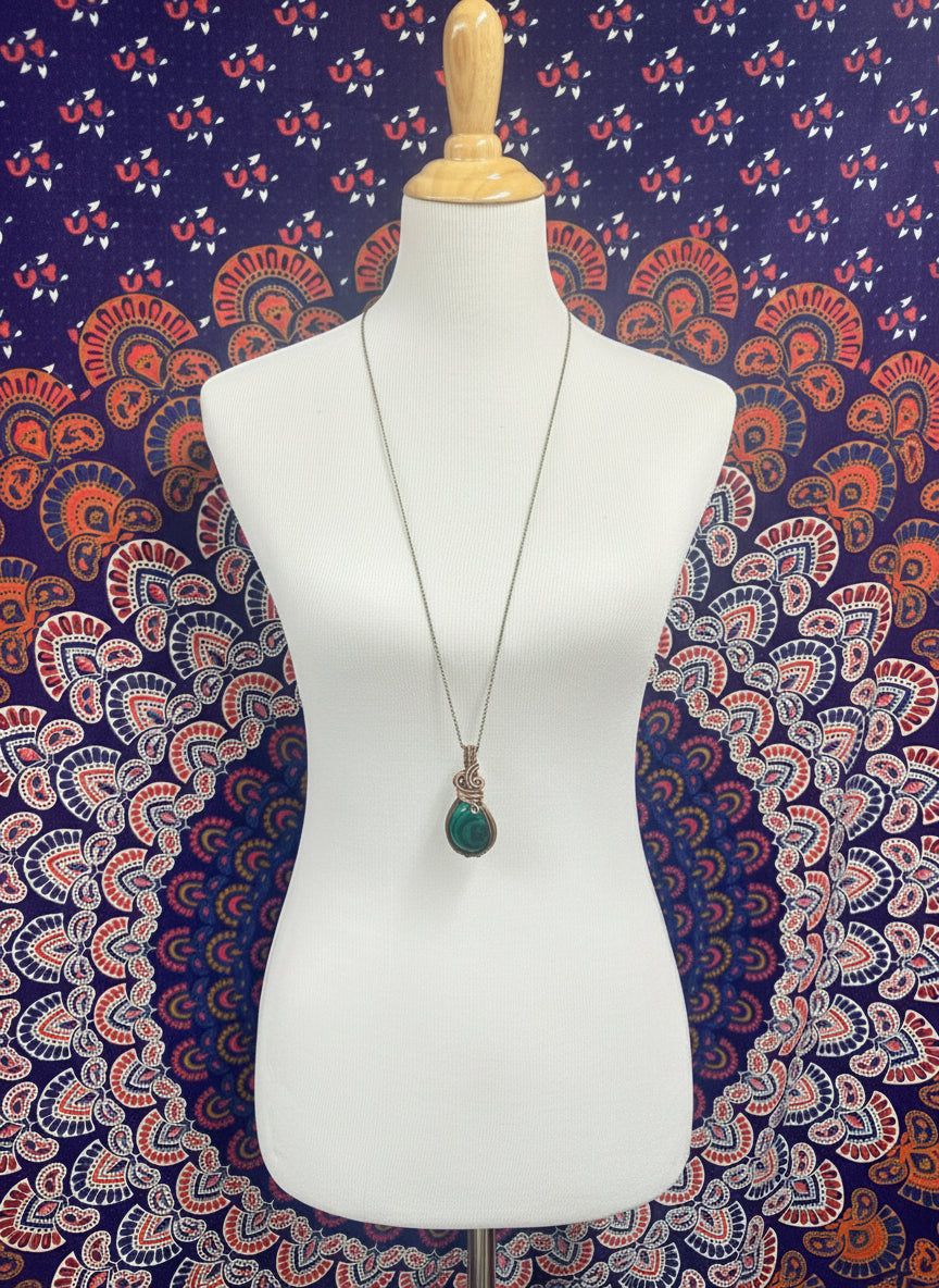Malachite copper wire wrapped pendant displayed on necklace bust with 36 inch brass chain