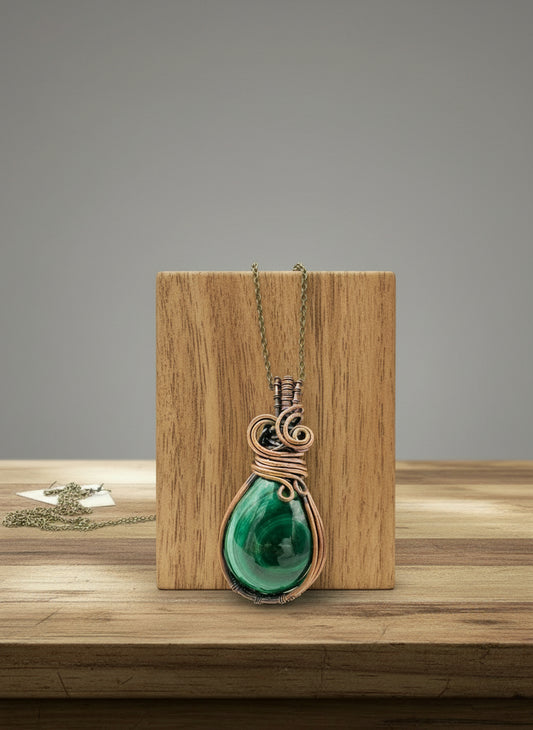 Front view of handcrafted copper wrapped malachite pendant on long brass chain