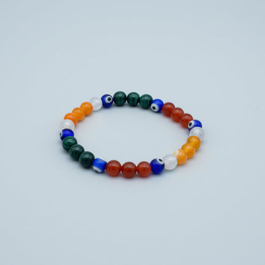 Multicolored beaded bracelet with evil eye-shaped beads on a wooden surface