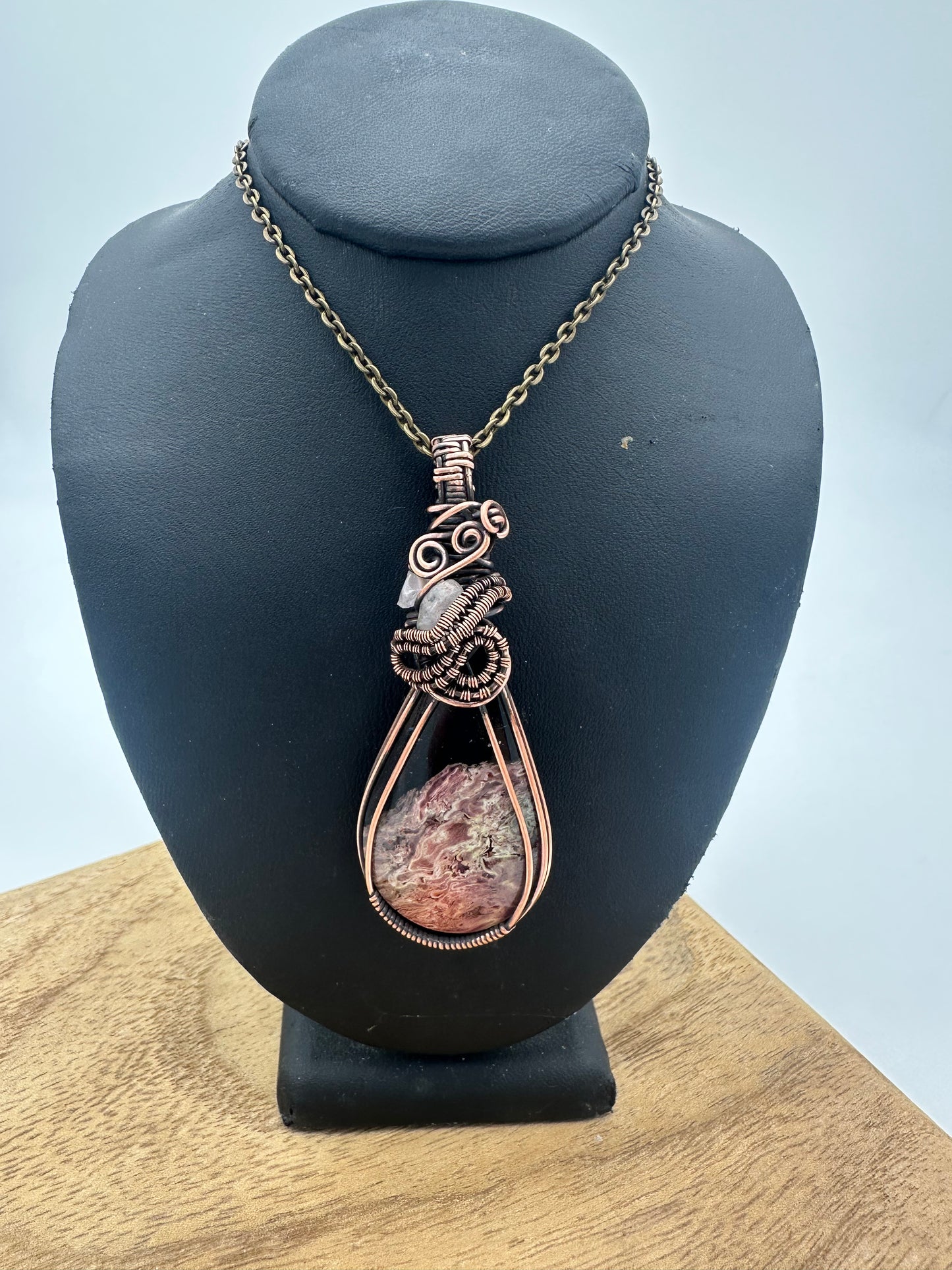 Detail view of petrified palm root fossil wrapped in warm copper wire