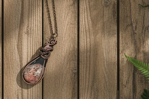 Petrified palm root pendant hand wrapped in copper wire showing natural grain