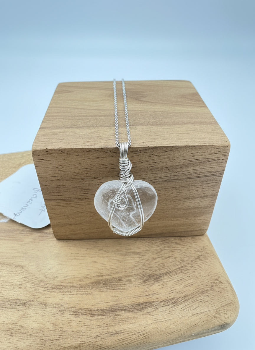 Close-up of heart-shaped quartz wrapped in .925 sterling silver showing clear crystal detail