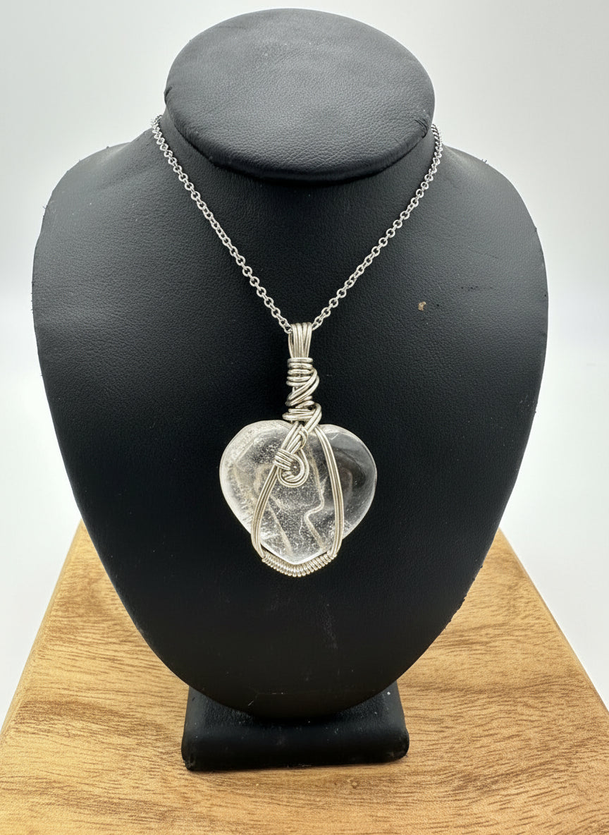 Heart-shaped quartz pendant wrapped in sterling silver displayed on necklace bust with 18 inch chain